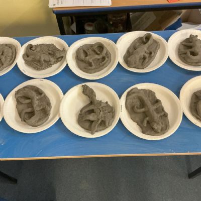 Children making clay lizards